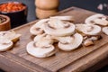 Beautiful young white champignons torn to slices on a dark concrete background Royalty Free Stock Photo