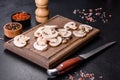 Beautiful young white champignons torn to slices on a dark concrete background Royalty Free Stock Photo