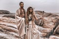 Beautiful young wild free couple in tribal costumes at the stone background