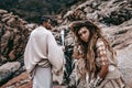 Beautiful young wild free couple in tribal costumes at the stone background