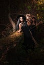 Beautiful young witches in dark forest.