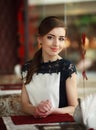 Beautiful young woman alone waiting at a table in restaurant Royalty Free Stock Photo