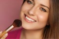 Beautiful young woman applying cosmetic powder product with make-up bamboo brush, beauty, makeup and skincare cosmetics model face Royalty Free Stock Photo