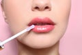 Beautiful young woman applying gloss on her perfect lips Royalty Free Stock Photo