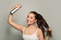 Beautiful young woman applying hair spray on her hair Royalty Free Stock Photo