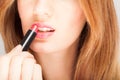 Beautiful young woman applying lipstick Royalty Free Stock Photo