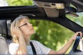 beautiful young woman applying make-up while driving car Royalty Free Stock Photo