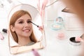 Beautiful young woman applying makeup near mirror Royalty Free Stock Photo