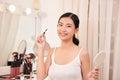 Beautiful young woman applying makeup near mirror in dressing room Royalty Free Stock Photo