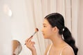 Beautiful young woman applying makeup near mirror in dressing room Royalty Free Stock Photo