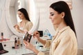 Beautiful young woman applying makeup near mirror Royalty Free Stock Photo