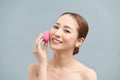 Beautiful young woman applying makeup using beauty blender sponge Royalty Free Stock Photo