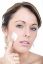 Beautiful Young Woman Applying Moisturizing Cream to her Face Royalty Free Stock Photo