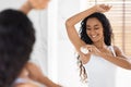 Beautiful Young Woman Applying Roller Deodorant To Armpit Zone In Bathroom Royalty Free Stock Photo
