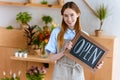 beautiful young woman in apron holding sign open and smiling at camera Royalty Free Stock Photo