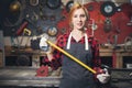 Beautiful young woman artisan engineer stands with ruler apron on background of craft tools. Concept small business in Royalty Free Stock Photo