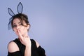 Beautiful young woman as easter bunny with rabbit ears on blue background Royalty Free Stock Photo