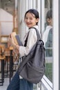 Beautiful young woman asian with backpack and book. College student carrying lots of books in college campus Royalty Free Stock Photo