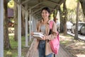 Beautiful young woman asian with backpack and book. College student carrying lots of books in college campus Royalty Free Stock Photo