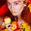 Beautiful young woman with autumn make up holding apples in her Royalty Free Stock Photo