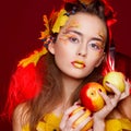 Beautiful young woman with autumn make up holding apples in her Royalty Free Stock Photo