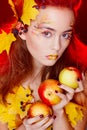 Beautiful young woman with autumn make up holding apples in her Royalty Free Stock Photo