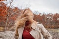 Beautiful young woman in autumn park. Face hidden behind hair, wind blowing hair of beautiful girl outdoor Royalty Free Stock Photo