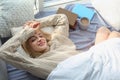 Beautiful young woman awaking and smiling at home, top view.