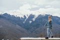 Beautiful young woman on  background of snowy mountains. Winter holidays travel. Copy space Royalty Free Stock Photo