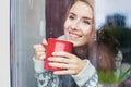 Beautiful young woman on a balcony enjoing morning with cup of coffee