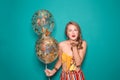 Beautiful young woman with balloons blowing kiss on color background Royalty Free Stock Photo