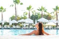 Beautiful young woman in the bathing suit girl is in the pool in a relaxed pose and sunbathes. Enjoying summer, relax. Vacation Royalty Free Stock Photo