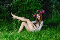 Beautiful young woman with beautiful legs in green spring grass Royalty Free Stock Photo