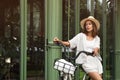 Beautiful woman with bicycle near modern building outdoors. Space for text Royalty Free Stock Photo