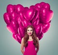 Beautiful young woman with big heart made of pink balloons on gray banner background Royalty Free Stock Photo