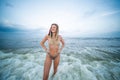 Beautiful young woman in bikini is coming out of the ocean on tropical beach Royalty Free Stock Photo