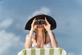 Beautiful young woman in bikini looking through binoculars at th Royalty Free Stock Photo