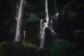 Beautiful young woman in bikini relaxing in front of waterfall. Ecotourism concept image travel girl