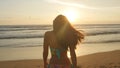 Beautiful young woman in bikini standing near the sea on sunset. Attractive girl with long hair posing on the ocean Royalty Free Stock Photo