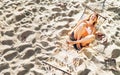 Beautiful young woman in bikini top swinging in hammock on the sandy beach and cheerful laughing in camera top view Royalty Free Stock Photo