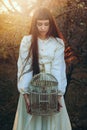 Beautiful young woman with bird cage