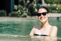 Beautiful young woman in black bikini relaxing in the hotel pool Royalty Free Stock Photo