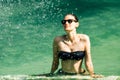 Beautiful young woman in black bikini relaxing in the hotel pool Royalty Free Stock Photo