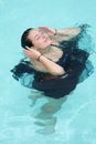 Beautiful young woman in black dress girl swimming in swimming pool Royalty Free Stock Photo