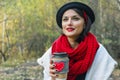 Beautiful young woman in a black hat drinks coffee from cozy cup on the nature. Outdoor picnic good mood Royalty Free Stock Photo