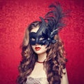 Beautiful young woman in black mysterious Venetian mask Royalty Free Stock Photo