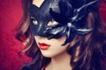 Beautiful young woman in black mysterious Venetian mask Royalty Free Stock Photo