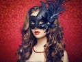 Beautiful young woman in black mysterious Venetian mask Royalty Free Stock Photo