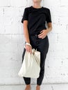 Beautiful young woman in black t-shirt and jeans holding a tote bag or shopper Royalty Free Stock Photo