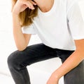 Beautiful young woman in blank white t-shirt and black jeans sitting on the stairs Royalty Free Stock Photo